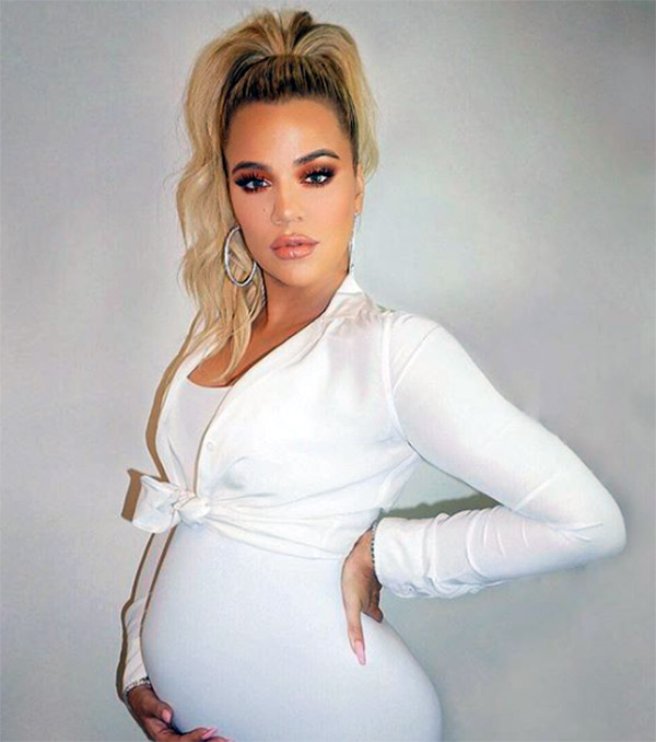  Khloé Kardashian in full white outfit showing off her Baby Bump 